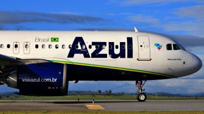 Aeronave da companhia Azul estacionado, com céu azul ao fundo. AZUL4