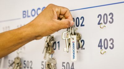 Mão segurando molho de chaves, com chaveiro da direcional.