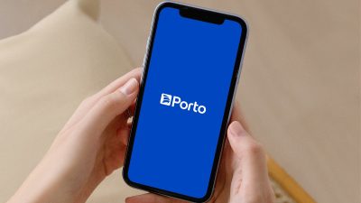 Imagem de mão segurando celular, com tela azul e logo da Porto Seguro no meio