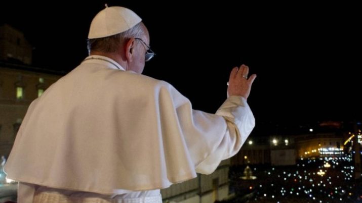 Imagem do papa Francisco, vestido de branco, acenando para uma multidão de um ponto alto do Vaticano