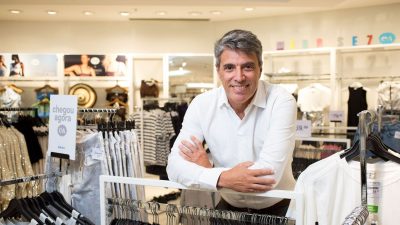 Paulo Correa, CEO da C&A, diante de uma arara de roupas na loja