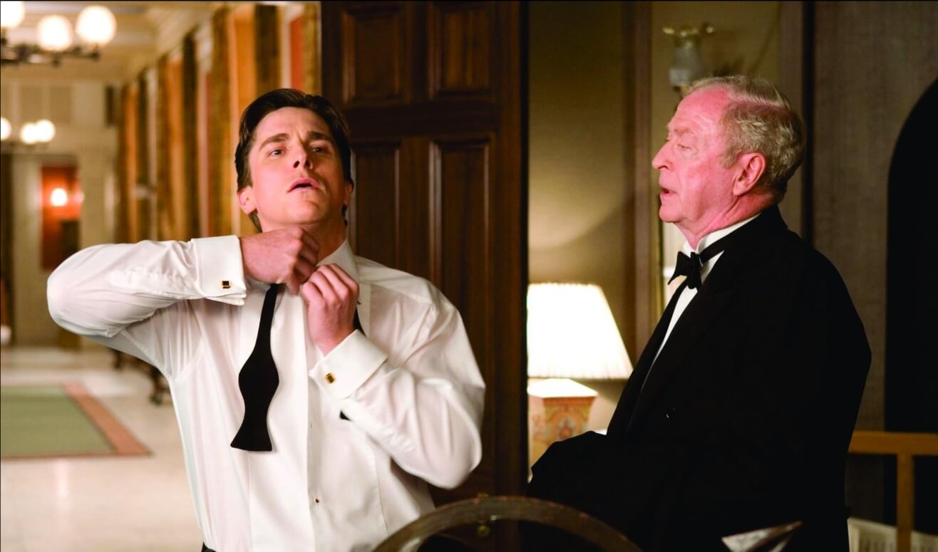 Christian Bale como Bruce Wayne e Michael Caine como Alfred no filme Batman Begins