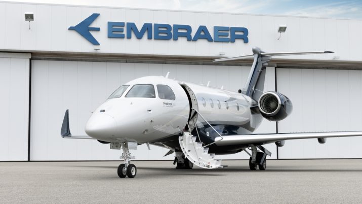 Um jato executivo da Embraer, o PRAETOR 500, em frente a marca da companhia.