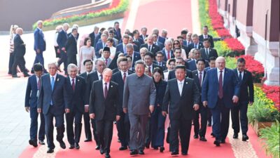 Foto mostra dezenas de autoridades caminhando em um tapete vermelho. Do lado esquerdo, em primeiro plano, o russo Vladimir Putin; ao centro, chinês Xi Jinping; e do lado direto, Kim Jong-un