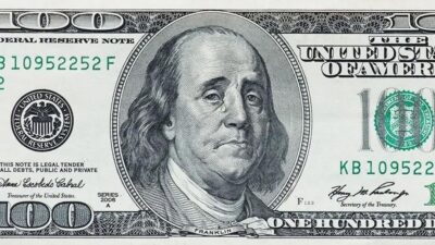 Cédula de 100 dólares americanos com o retrato de Benjamin Franklin, símbolo da moeda dos EUA usada como referência mundial em câmbio, comércio internacional e investimentos.
