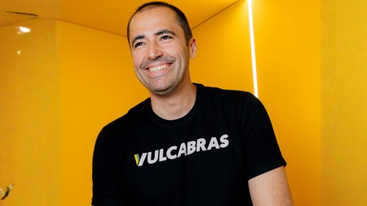 "Imagem de Wagner Dantas, CFO da Vulcabras, sorrindo com camiseta da empresa, em ambiente de fundo amarelo.