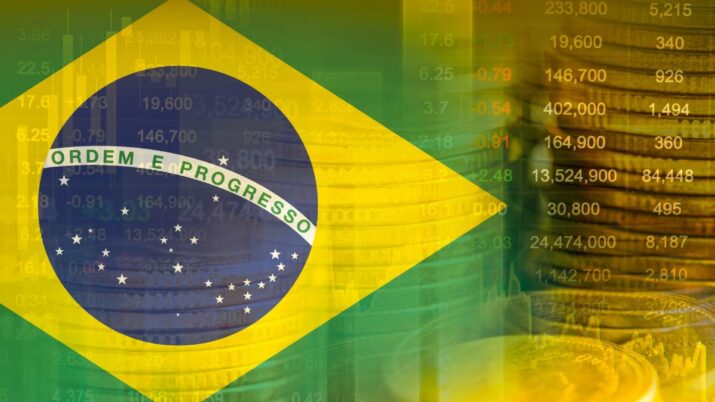 Bandeira do Brasil com moedas de real ao fundo
