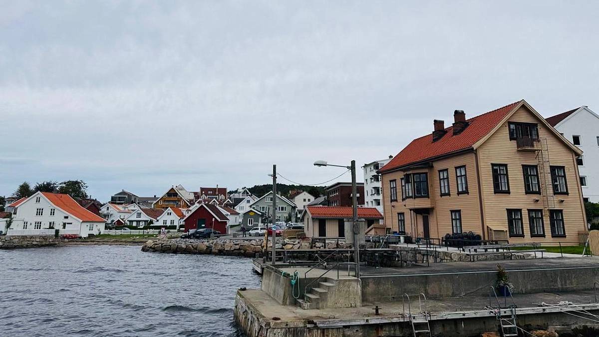 Imagem do cais de Drobak, na Noruega, com barcos e casas típicas ao fundo