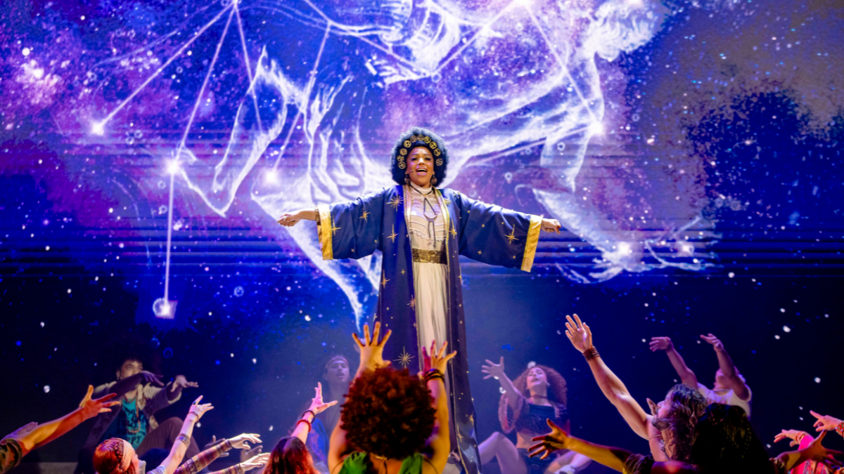 “Aquário”, tema de Hair que ganhou versão brasileira gravada pela cantora Ludmilla na versão 2025; no palco, quem canta a atriz Beatriz Martins