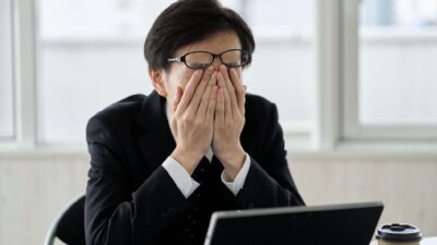 Chefe atordoado em frente ao computador - dificuldades na liderança