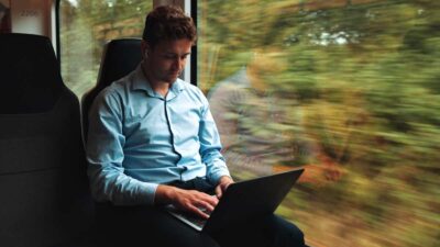 investidor olhando seus investimentos em viagem de trem a turismo ou a trabalho