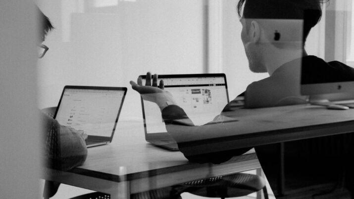 Foto em branco e preto de pessoas trabalhando no notebook