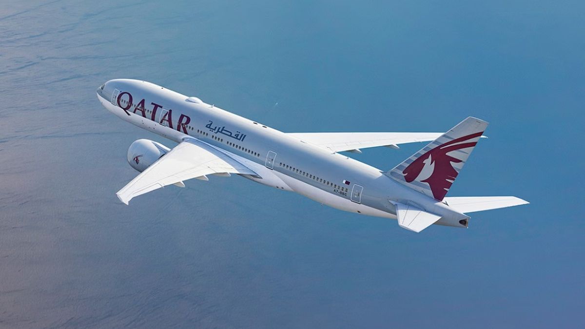 Avião da Qatar voando sobre o mar