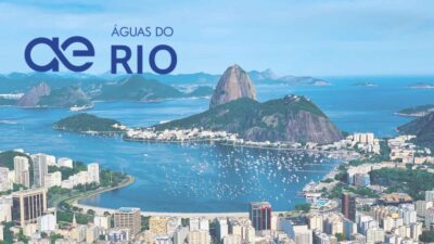 Montanhas do Rio de janeiro, ilhadas pelo mar, com prédios ao fundo.