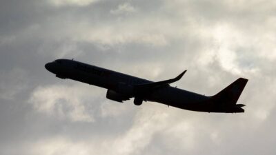 Em um céu nublado, a sombra de um avião voando