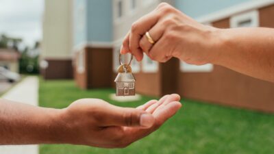 Mercado Imobiliário Investindo Dinheiro da Casa Minha Casa Minha Vida Detalhe das mãos do agente imobiliário entregando as chaves