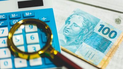 Dinheiro, calculadora e uma lupa