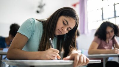 Estudante adolescente escrevendo na sala de aula