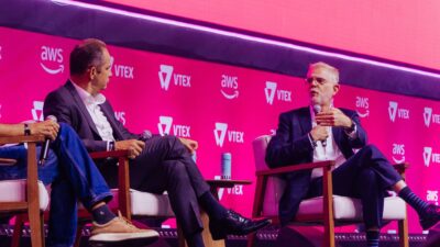 À esquerda, Fernando Honorato, economista-chefe do Bradesco e, à direita, com o microfone, João Scandiuzzi, estrategista-chefe do BTG Pactual, em painel do evento VTEX Day 2026