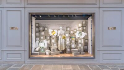 Fachada da loja da Dior, com paredes brancas e vitrine aesthetic
