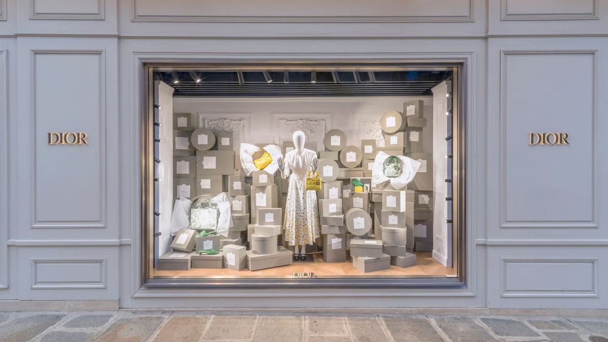 Fachada da loja da Dior, com paredes brancas e vitrine aesthetic