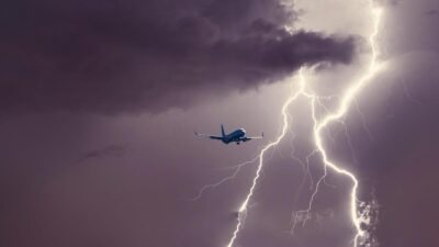 Imagem mostra um avião passando por nuvens de tempestades e relâmpagos