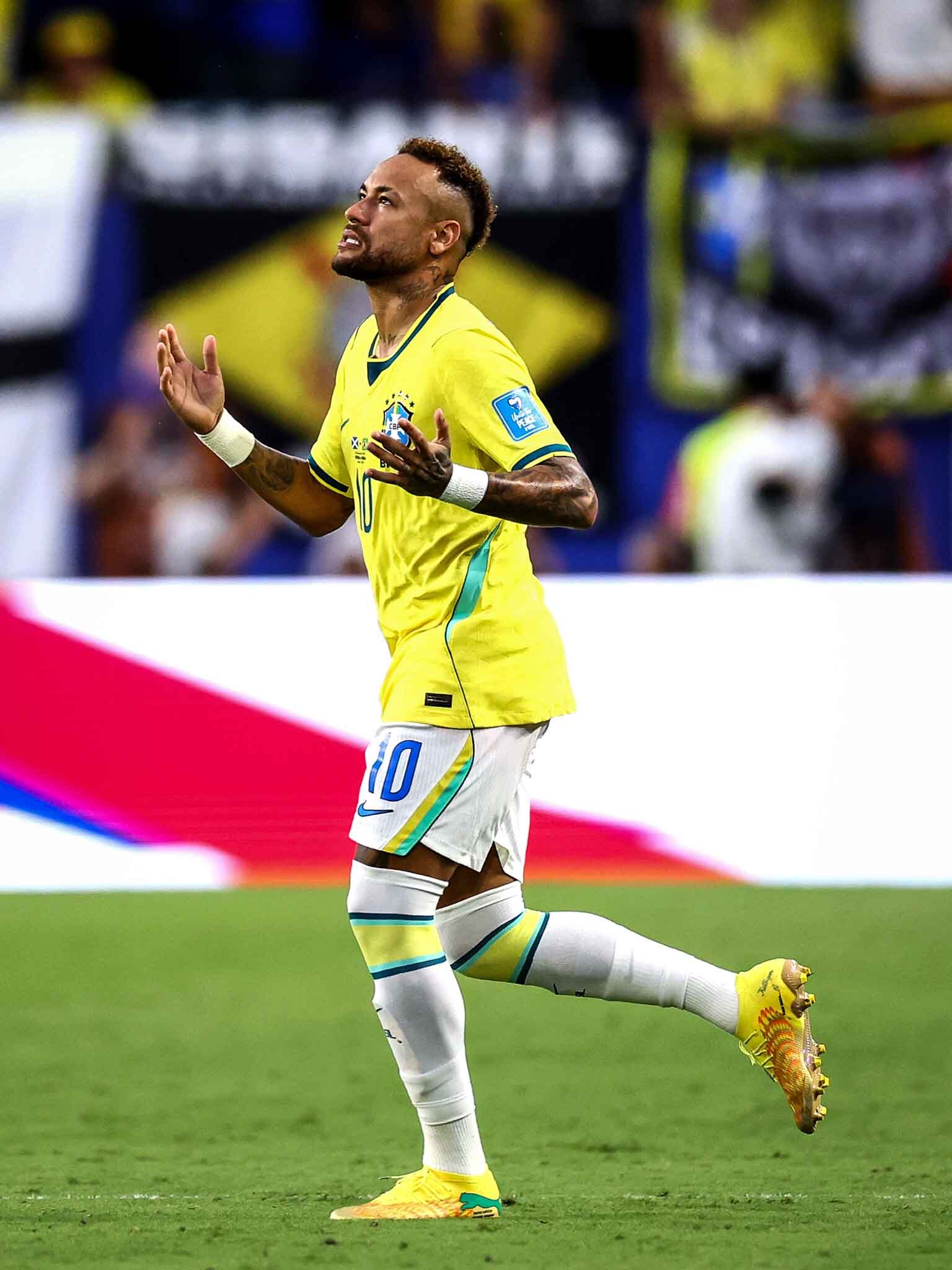 Neymar aparece no gramado, correndo, ohando para cima 