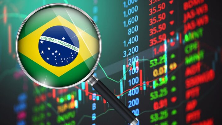 Montagem com um fundo de gráfico de ações e a bandeira do Brasil dentro de uma lupa