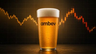 Copo de cerveja dourada e gelada centralizado em primeiro plano, com gotas de condensação visíveis no vidro. Ao fundo, desfocado, aparece um gráfico financeiro com velas e linhas de mercado em tons de laranja e vermelho, simbolizando o impacto de fatores econômicos e tributários sobre a Ambev e o setor de bebidas.
