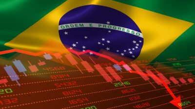 Imagem com a bandeira do Brasil ao fundo e um gráfico vermelho com números e uma seta apontando para baixo representando a queda do ibovespa