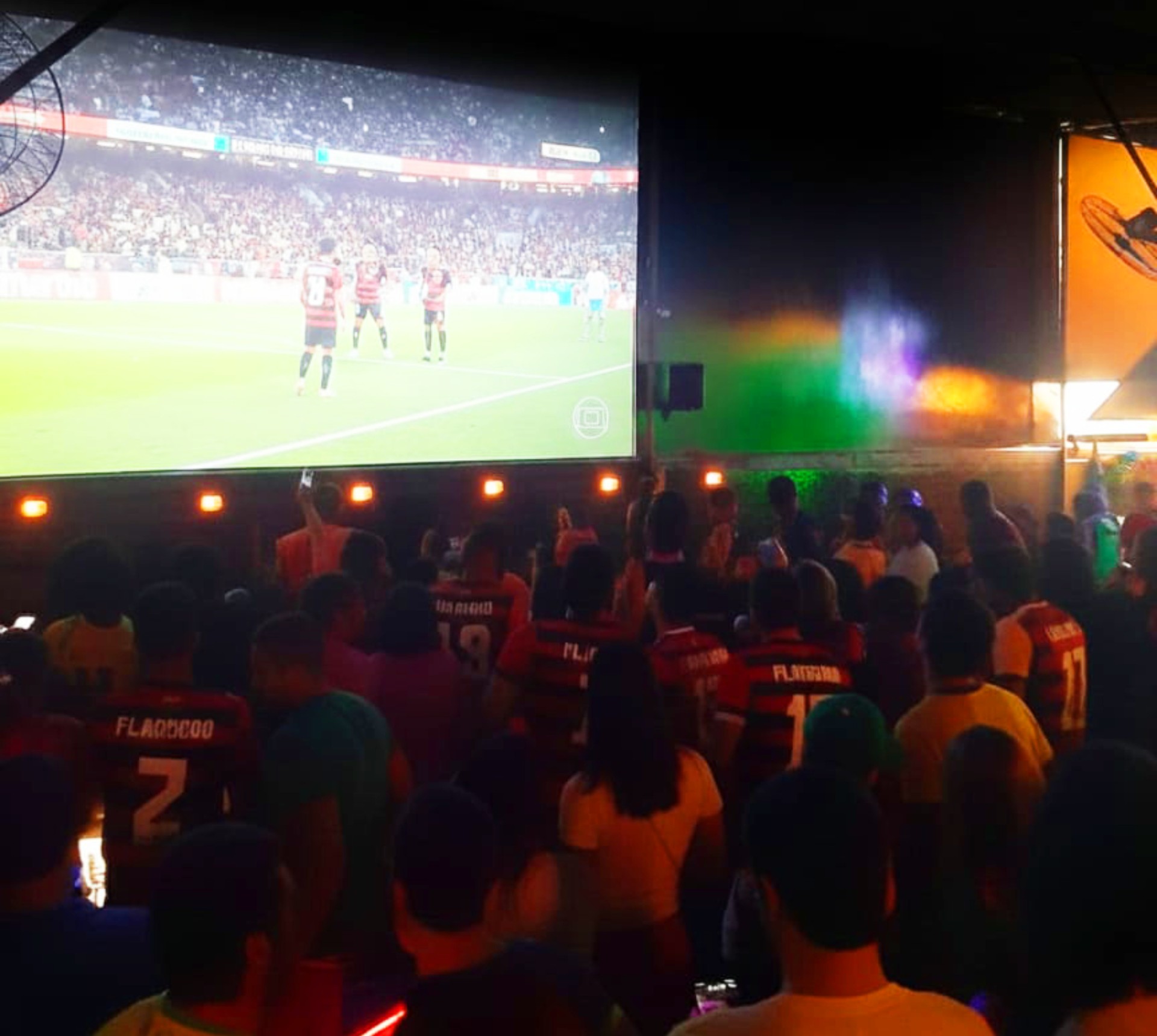 dezenas de torcedoras assistindo futebol pelo telão