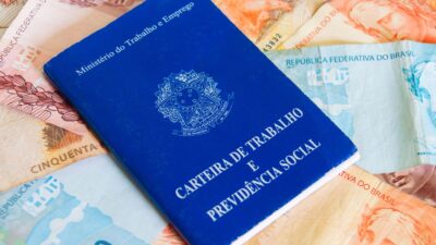 Carteira de trabalho e, ao fundo, dinheiro