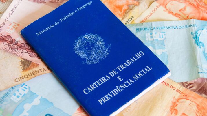 Carteira de trabalho e, ao fundo, dinheiro