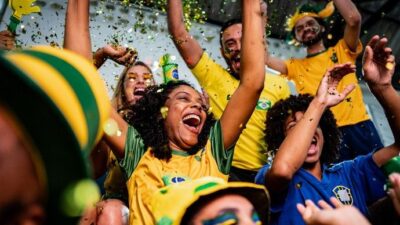 Torcedor brasileiro adulto médio comemorando com paixão e empolgação