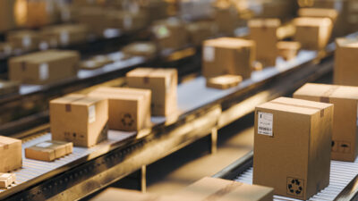 Packages moving on conveyor belts in a busy distribution warehouse for shipping and logistics operations