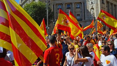 Pessoas segurando bandeiras da Espanha.