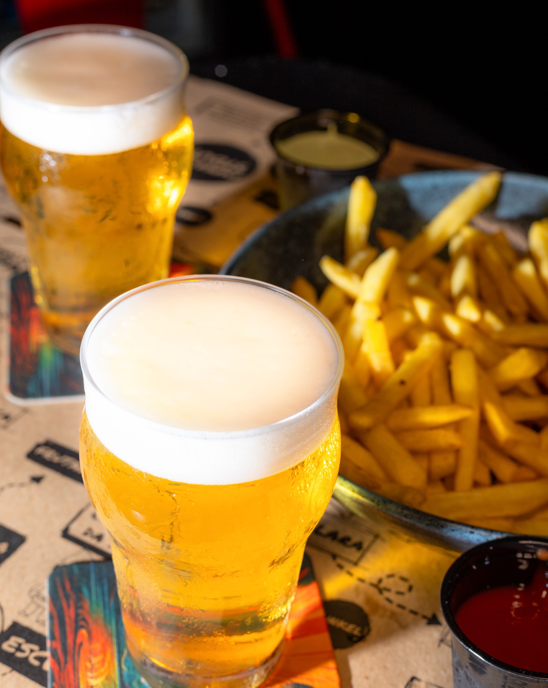 cerveja artesanal em copo de vidro com fritas