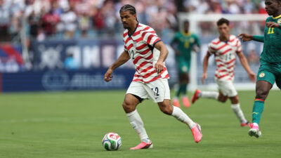Foto de jogador de futebol da seleção dos Estados Unidos em campo.