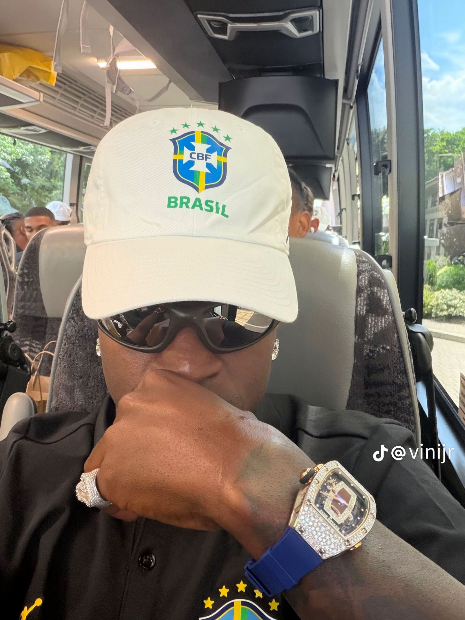 vini com boné e uniforme da seleção brasileira e relógio no pulso