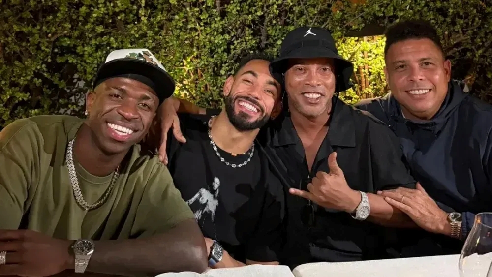 Vini Jr, Matheus Cunha, Ronaldinho Gaúcho e Ronaldo sentados lado a lado em restaurantes