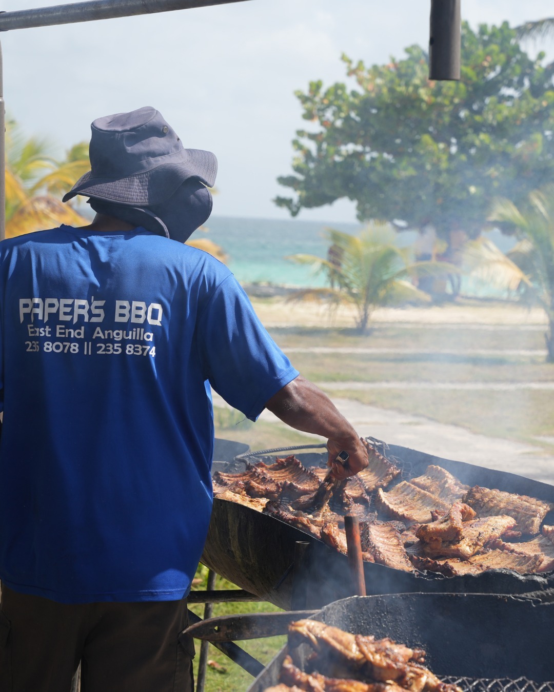 Homem prepara churrasco em Anguilla