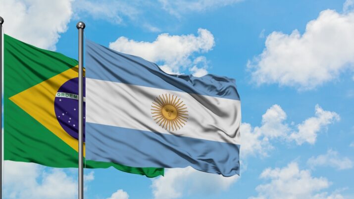 Com um céu azul ao fundo, bandeira de Brasil e Argentina aparecem em primeiro plano