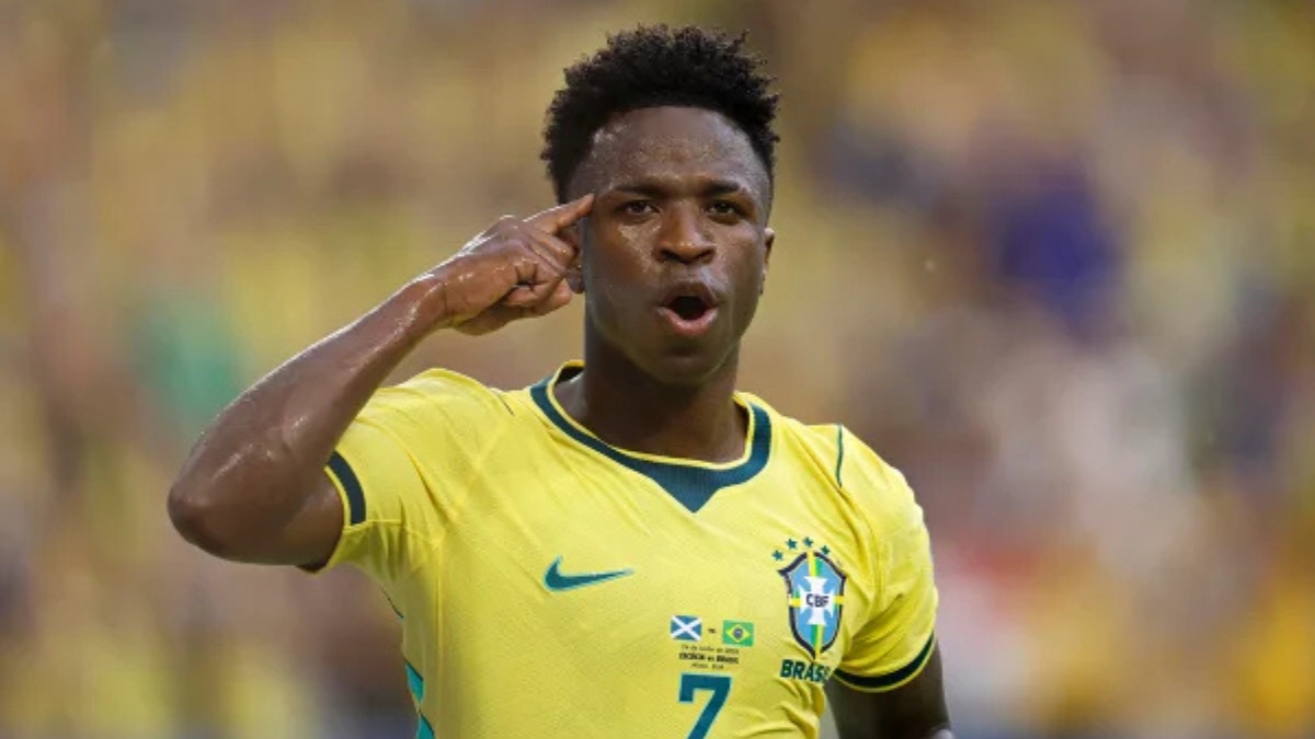 Vini Jr com dedo na têmpora vestindo camisa da seleção brasileira