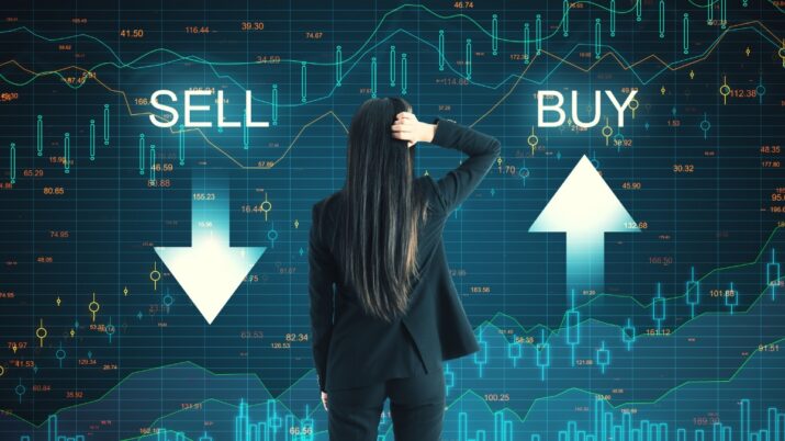 Mulher de costas observa gráficos financeiros com setas de compra e venda, simbolizando dúvidas sobre investimentos no mercado de ações