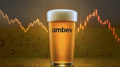Copo de cerveja dourada e gelada centralizado em primeiro plano, com gotas de condensação visíveis no vidro. Ao fundo, desfocado, aparece um gráfico financeiro com velas e linhas de mercado em tons de laranja e vermelho, simbolizando o impacto de fatores econômicos e tributários sobre a Ambev e o setor de bebidas.