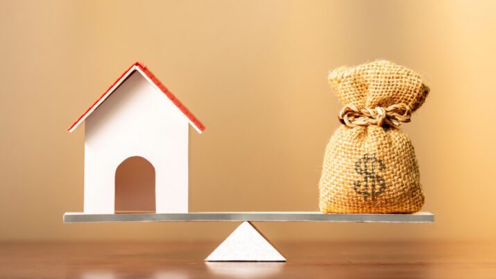 Imagem com um imóvel e saco de dinheiro para representar crédito imobiliário