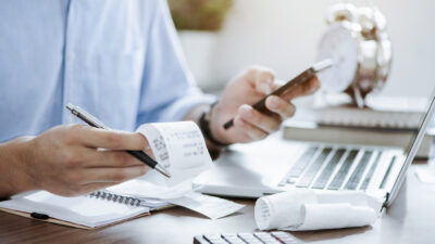young man holding pen with bills working for calculate business data, taxes, bills payment, Start up counting finance. accounting, statistics, and analytic research concept