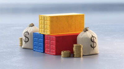USA trade war and international tariffs. Concept featuring stacked shipping containers with money bags and coins. Global import export costs and economic policies