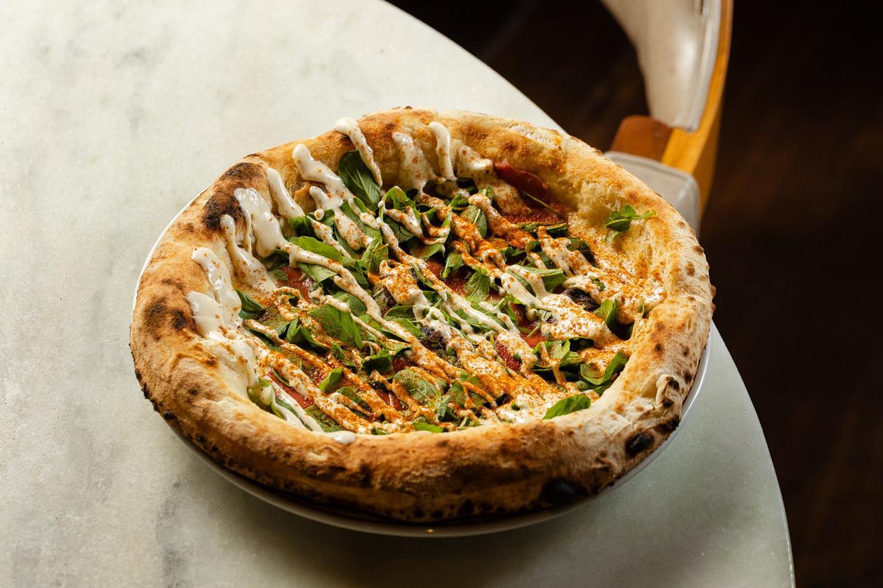 pizza redonda em cima de mesa de mármore