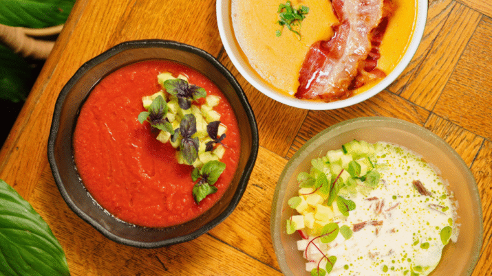 Três pratos com líquidos vistos de cima: Gazpacho vermelho, salmorejo alaranjado e ajoblanco pálido